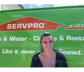 Woman with red hair standing in front of a Servpro vehicle