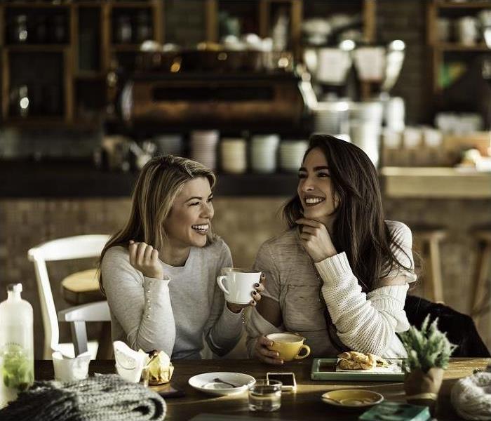 Two women sitting in coffee shop drinking coffee