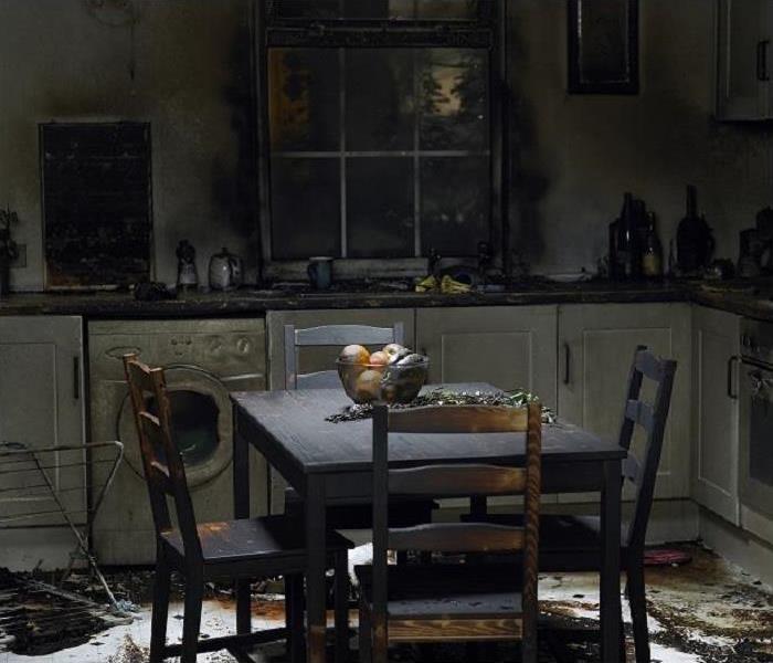 Fire damaged kitchen. Charred furniture; smoke on walls and cabinets