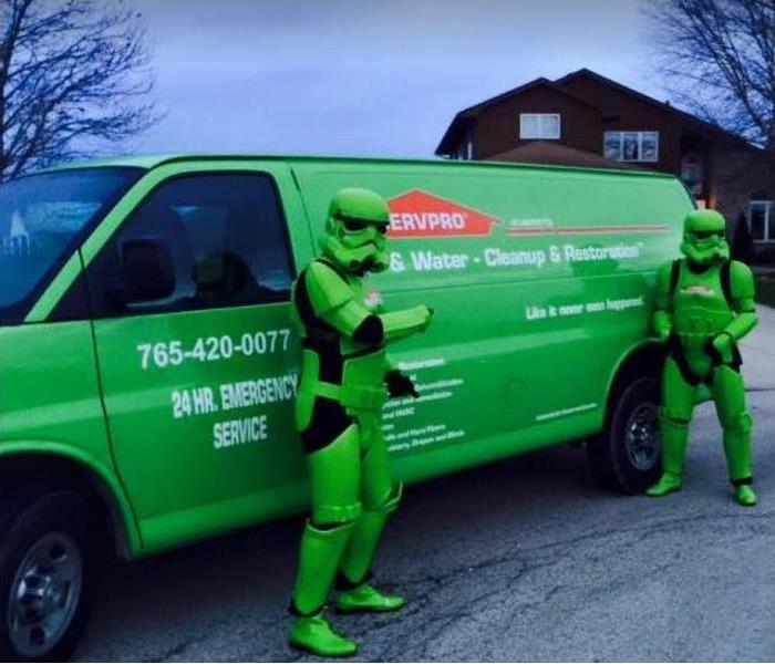 SERVPRO techs in superhero costumes in front of SERVPRO Vehicle