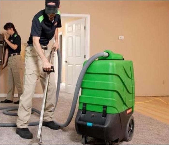 SERVPRO tech using extraction equipment to remove water from carpet