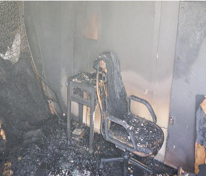 furniture in room burned after fire with soot and dust