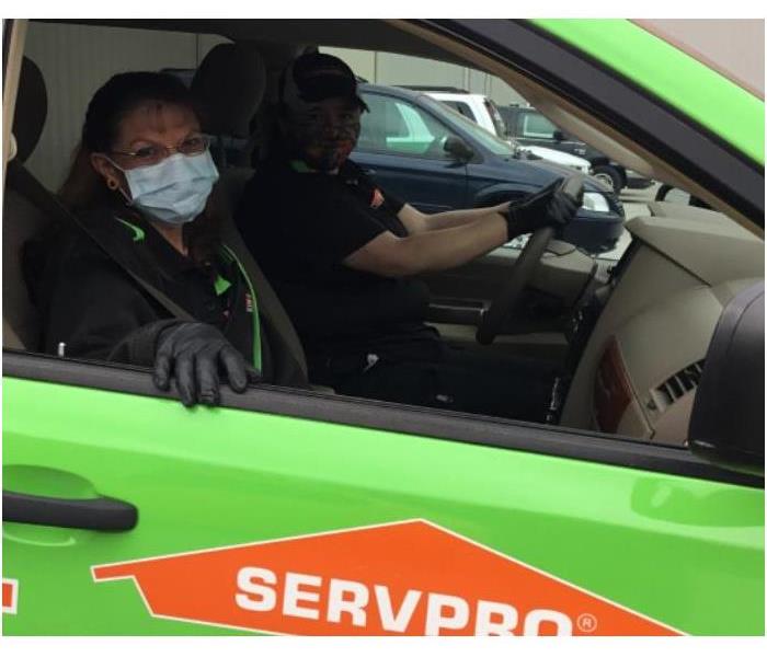 2 SERVPRO employees in work vehicle wearing PPE