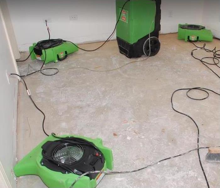 Fans and dehumidifiers running in a bedroom with a concrete floor