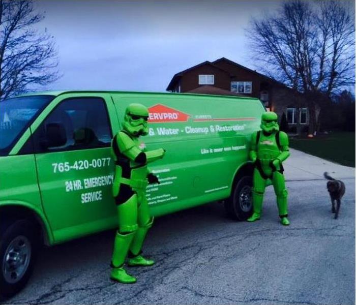 SERVPRO techs dressed as super-heroes standing in front of SERVPRO van
