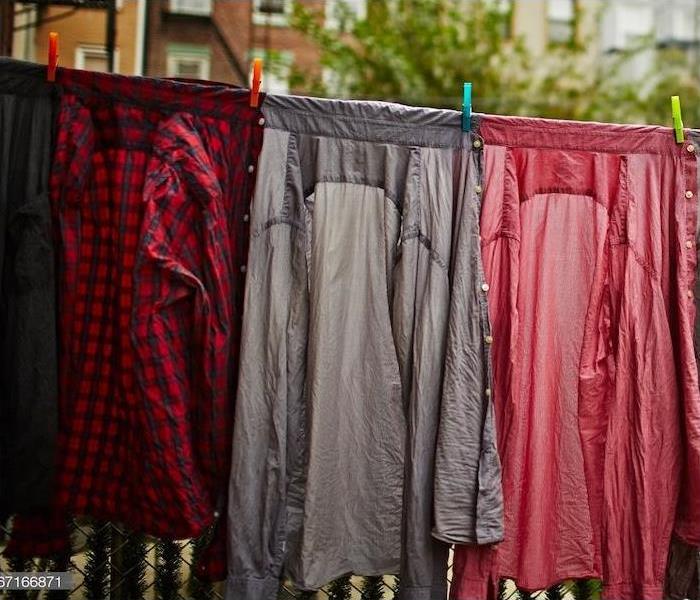Wet clothes hanging on an outside clothesline. 